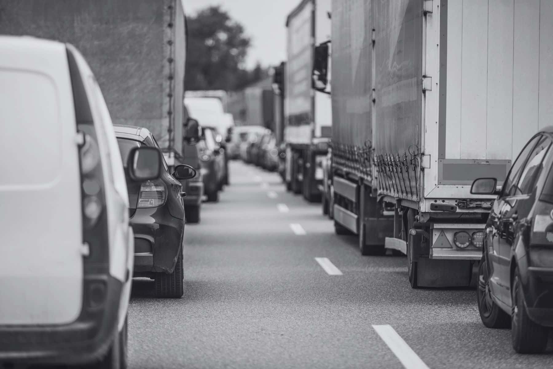 two lanes of traffic including cars and tractor trailer heavy trucks