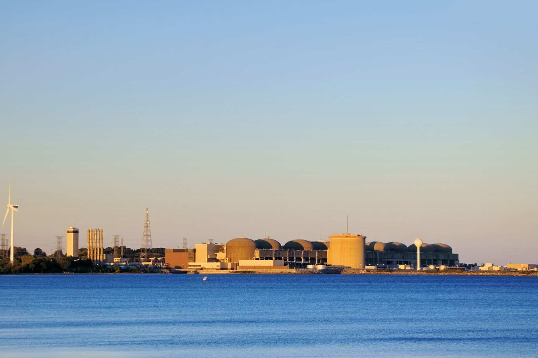 Distant landscape photo of nuclear power plant in Pickering,Ontario with the water from Frenchman's Bay in the foreground.
