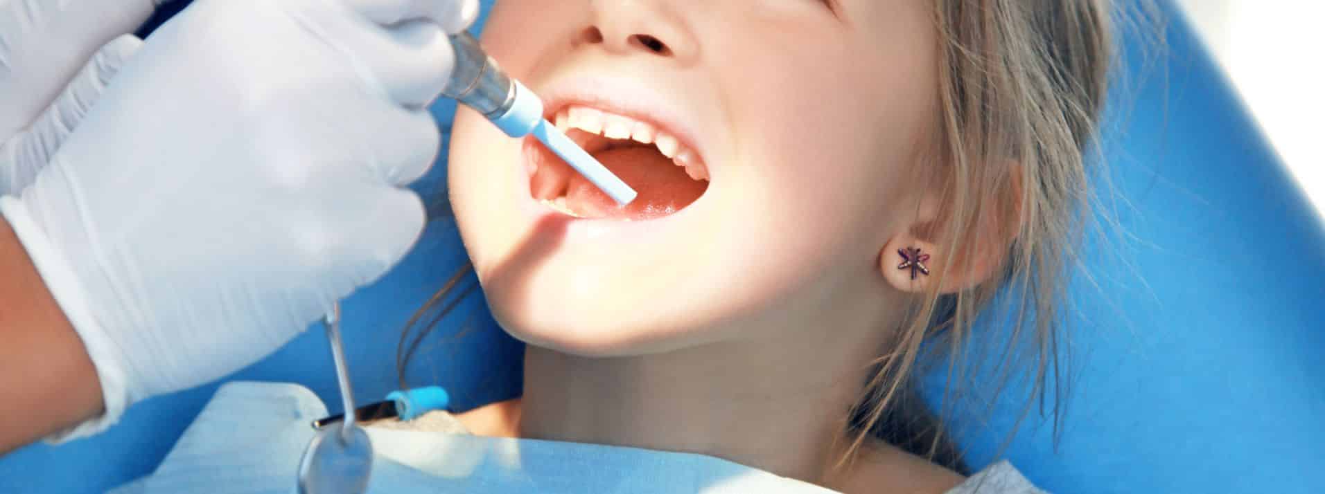 A girl at a Dental Clinic having her tooth fixed