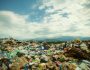 Garbage landfilll in theforeground with blue sky and mountains in the background.